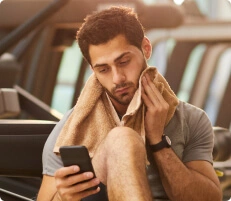 Homem se secando mexendo no celular.