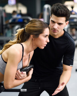 Personal orientando mulher a como fazer um exercício